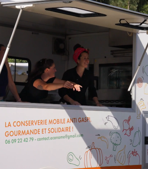 Les trois jeunes femmes, Julie, Valentina et Anne-Lise, soulèvent l’auvent de leur camionnette siglée au nom de l’association